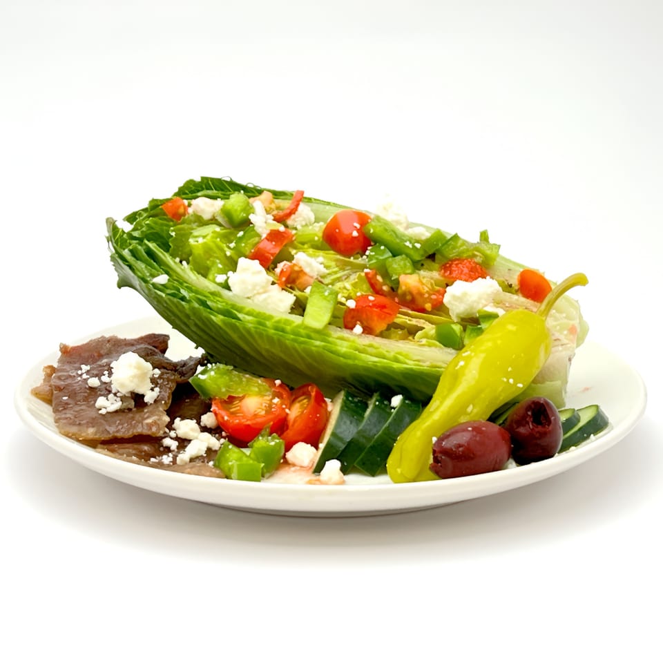 A Wedgies salad with gyro meat, feta, tomatoes, peppers, cucumbers, olives, and a pepperoncini.