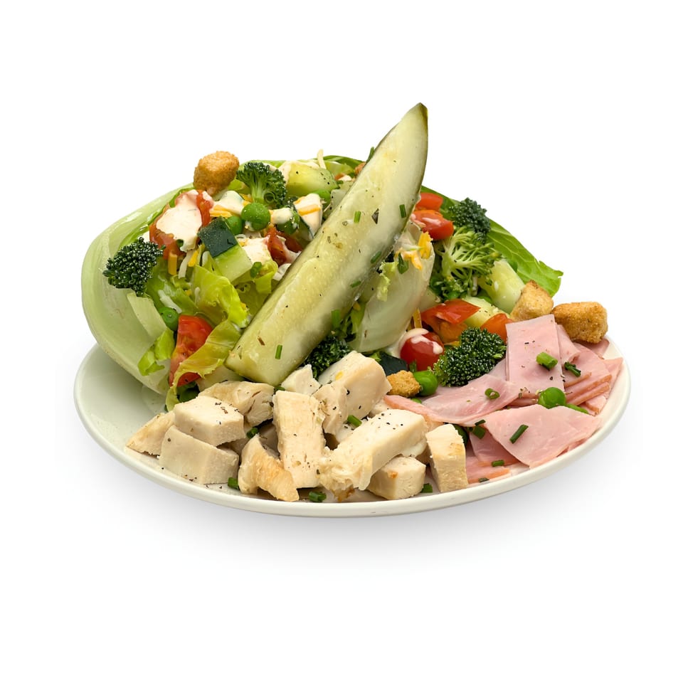 Wedgies salad with lettuce, broccoli, tomatoes, chicken, ham, croutons, and a pickle spear.